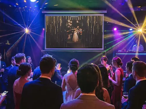 Guest photos playing on a projector screen at a party